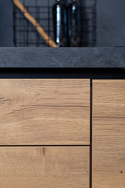 Houtlook-front-en-donker-werkblad-in-landelijke-keuken