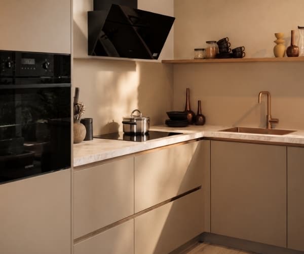 Beige hoekkeuken met een beige marmer werkblad en een gouden kraan en spoelbak